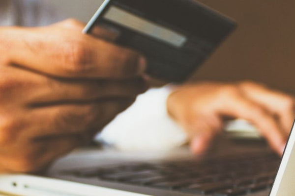 Personne devant un ordinateur portable avec une carte bancaire à proximité