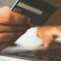 Personne devant un ordinateur portable avec une carte bancaire à proximité
