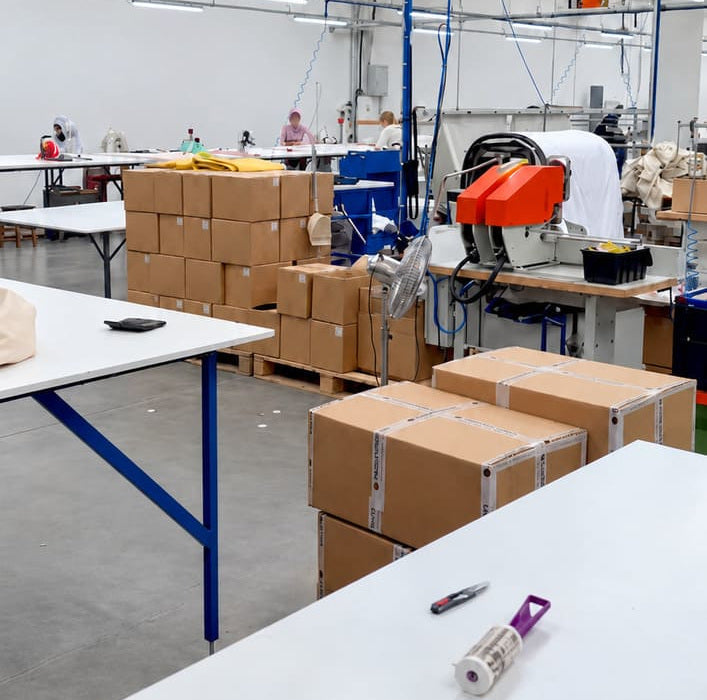 Atelier de confection partenaire de Nokomis : tables de travail, machines et cartons