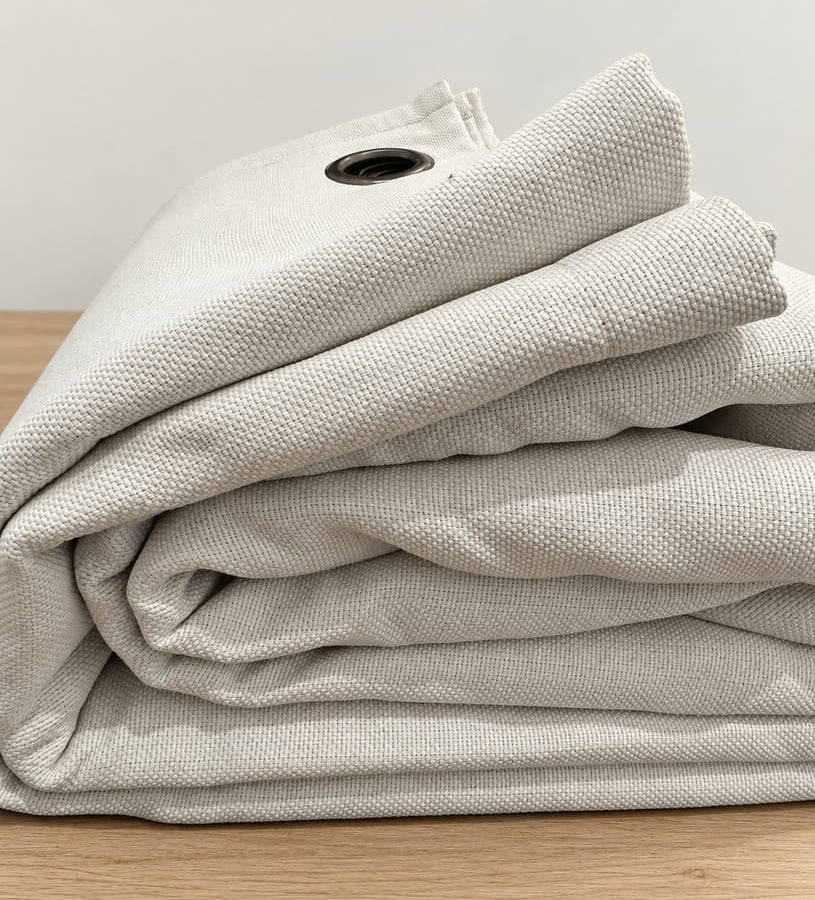 Détail du tissu natté du rideau phonique Performance PLUS blanc Nokomis, plié, avec un œillet